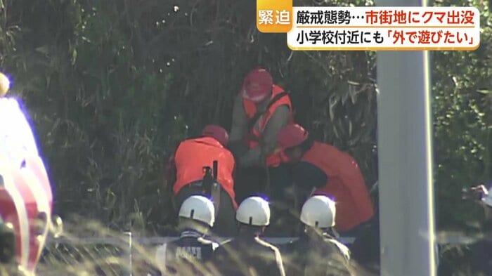 黒っぽい物体を抱える