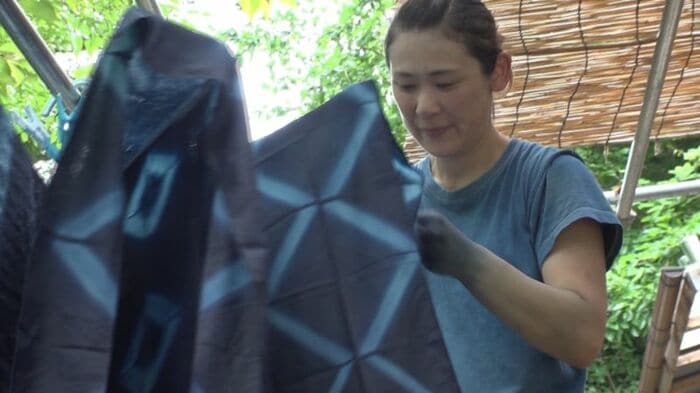 藍染めの作業をしながら、近くで遊ぶ子供たちを見守る
