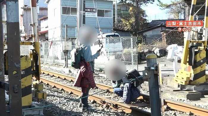 線路に座り込んで撮影する観光客