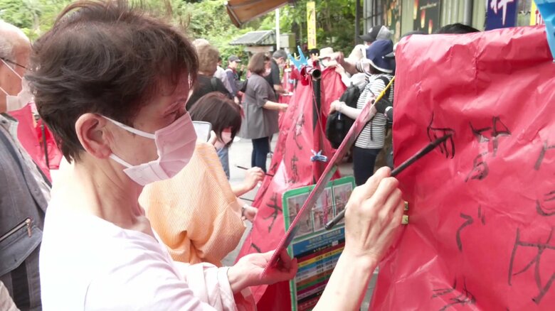 ランタンに願い事を書く観光客