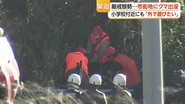 黒っぽい物体を抱える