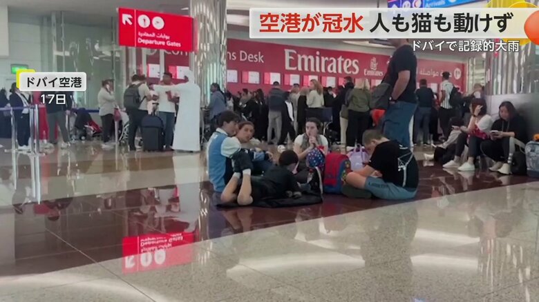 疲れ切った様子で床に座り込む人の姿が見られたドバイ国際空港