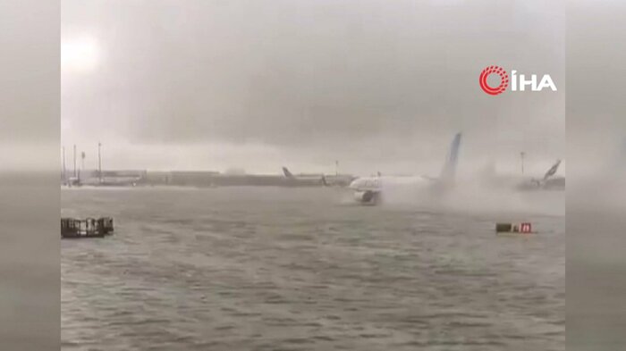 冠水した滑走路で水しぶきをあげながら進む航空機
