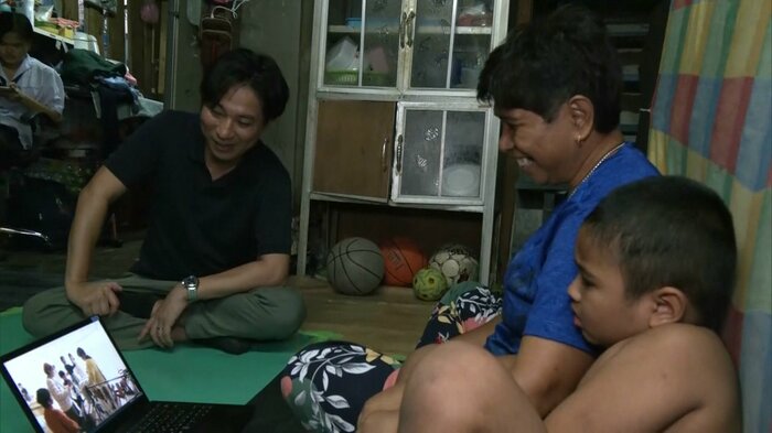 映像を見る記者とダオさんと孫