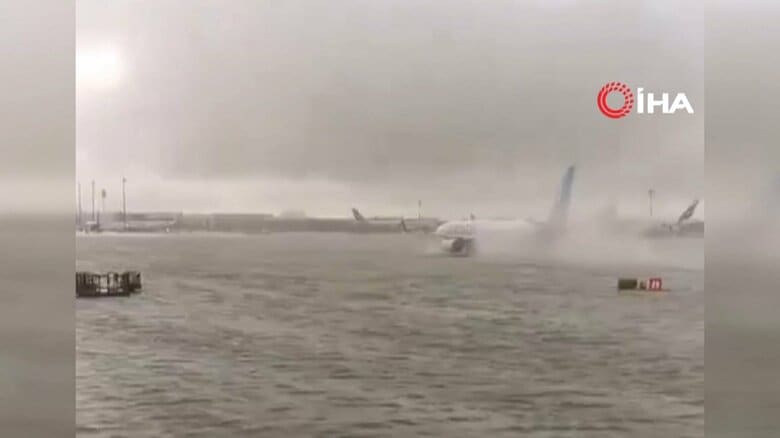 冠水した滑走路で水しぶきをあげながら進む航空機