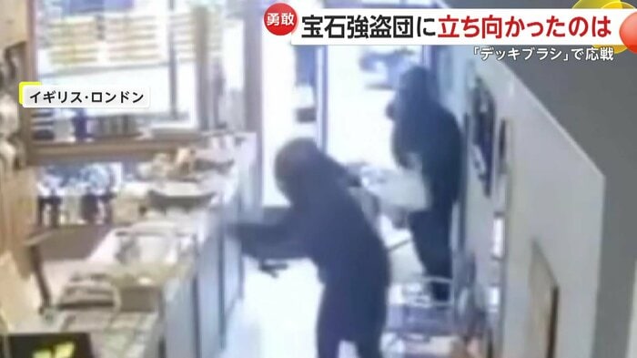 ショーケースを壊す強盗犯の1人（IHA）