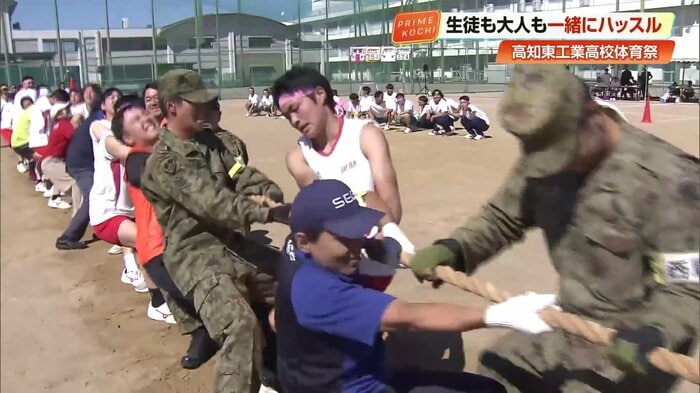 全力で綱を引く大人と生徒