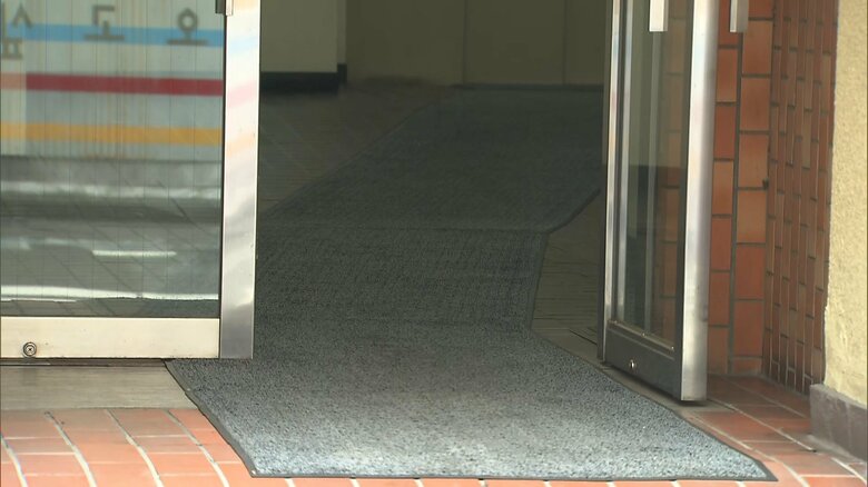 ビルの敷地内で、容疑者とみられる男が、血を流して倒れていたとのこと。