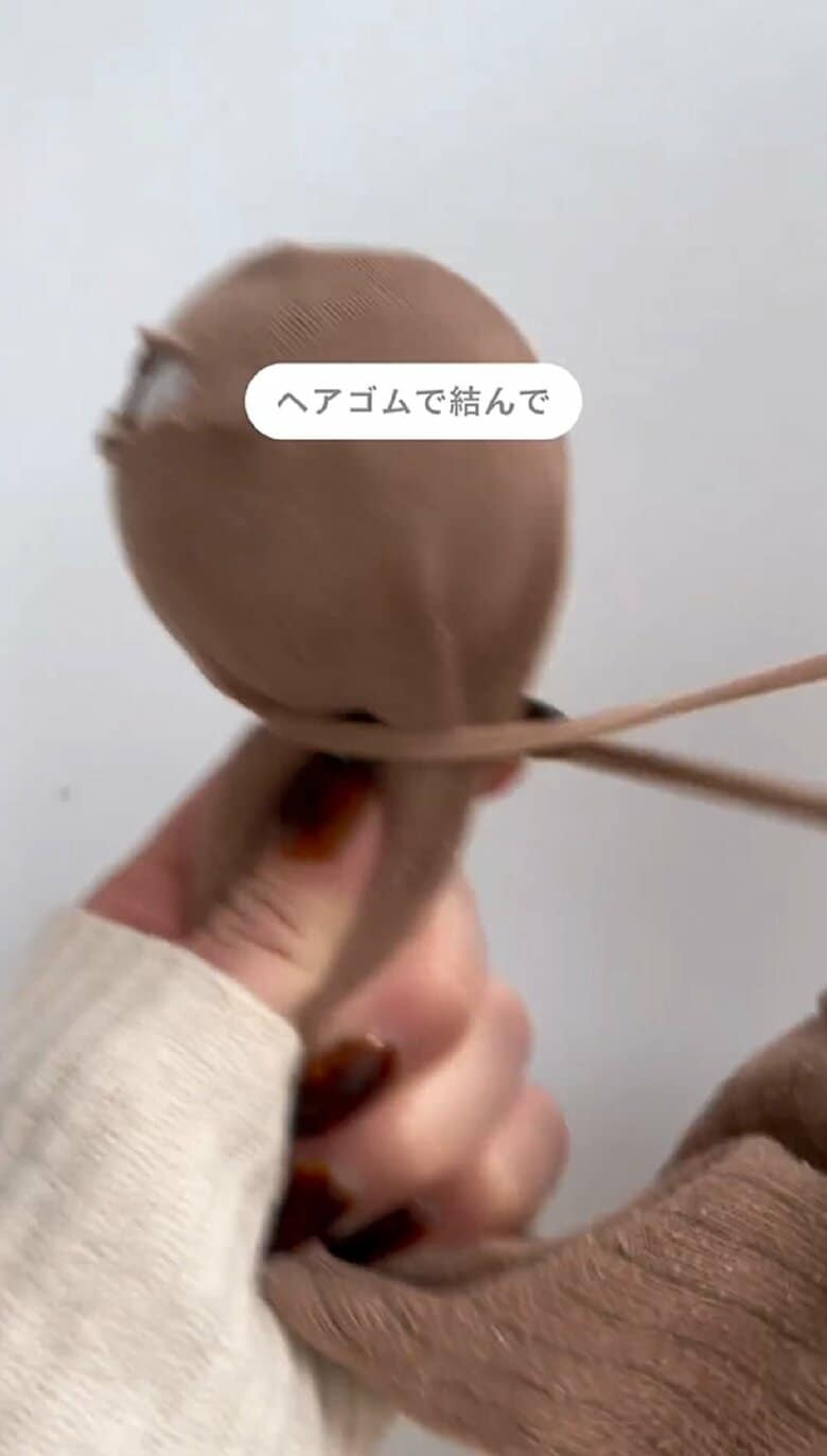 靴下の中にカプセル玩具の容器を入れ、ヘアゴムで固定