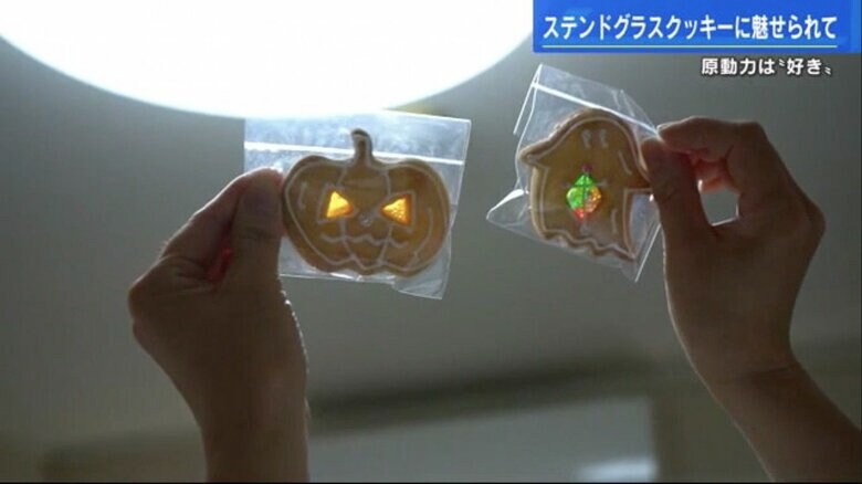 ハロウィーンのステンドグラスクッキーを光にかざす