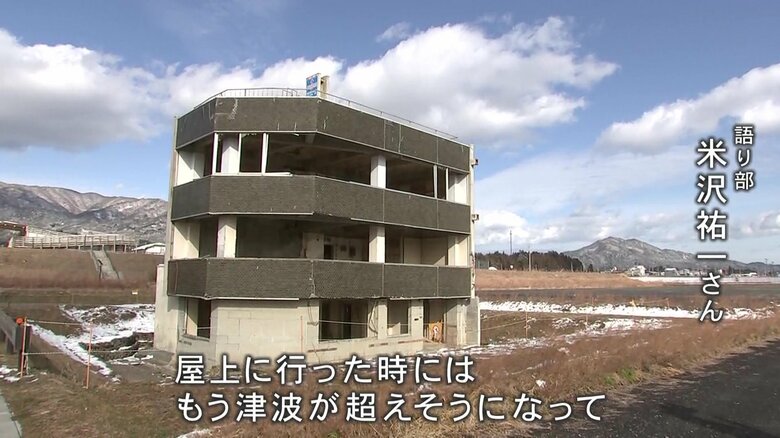 震災遺構の「米沢商会ビル」の前で震災の記憶を伝える語り部・米沢祐一さん