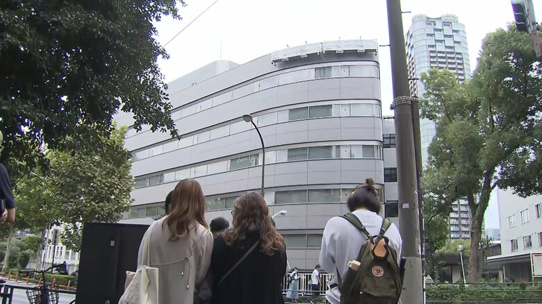 看板掛け替え作業を見つめる人たち