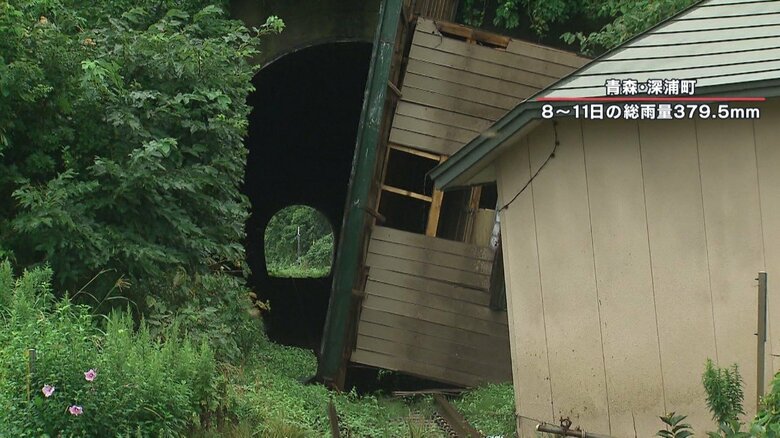 線路の上には、住宅が横向けに倒れていた