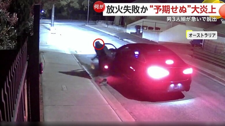 住宅に何やら液体をかけ始める男