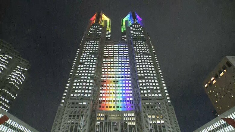 申請受付が始まった11日、虹色にライトアップされた東京都庁