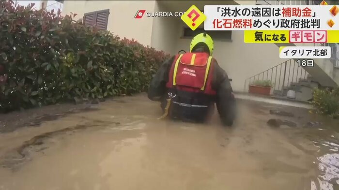 18日、イタリア北部。胸まで水に浸かりながら、救助を続ける救助隊