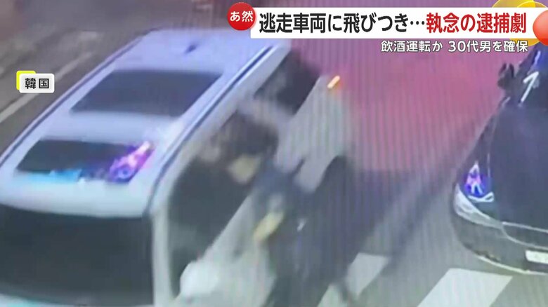 運転席側のドアに飛びつきしがみついた警察官