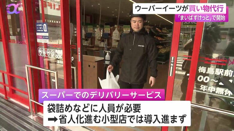 買い物代行サービスで、袋詰めした商品を手に店を出るUber Eatsの配達員