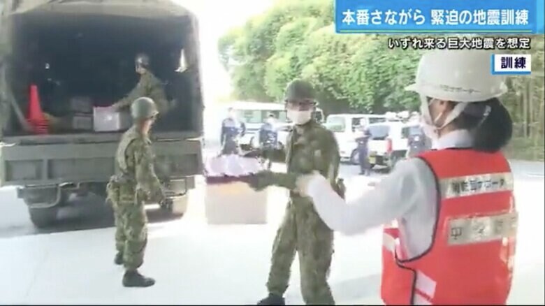 自衛隊車両に積まれた救援物資を受け取る消防団サポーター