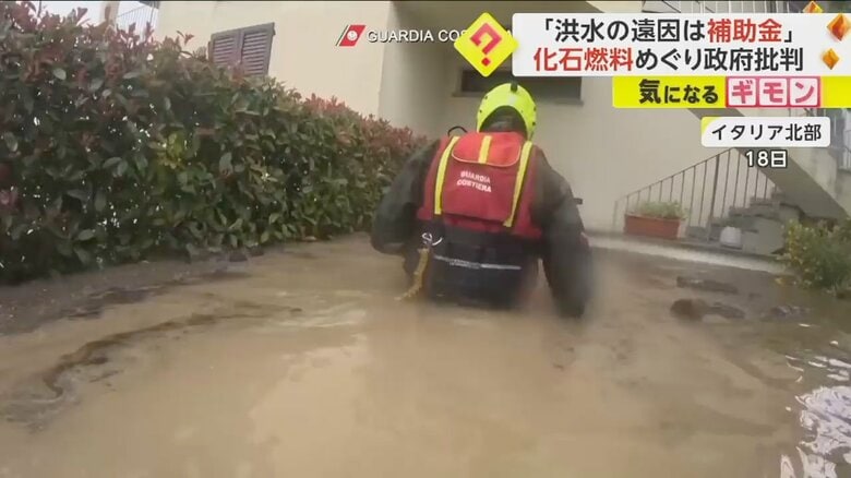 18日、イタリア北部。胸まで水に浸かりながら、救助を続ける救助隊