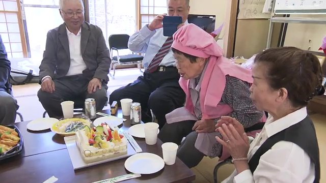 ケーキのロウソクを吹き消すミドリさん