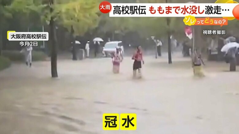 茶色い水で冠水したコースで、足を上げ必死に走ろうとする選手