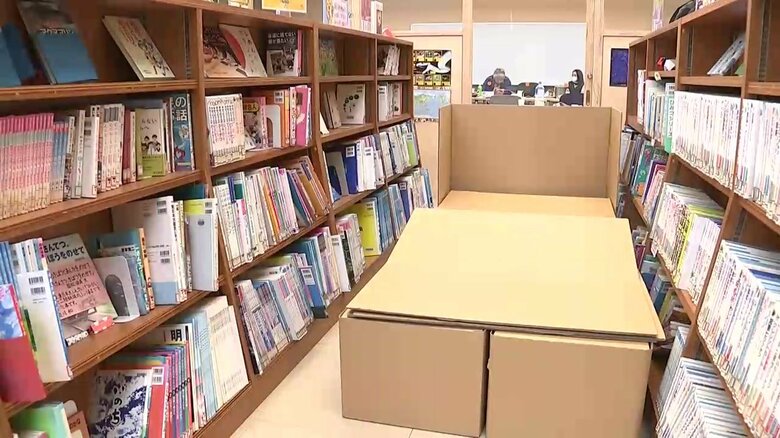 避難所では本棚に挟まれた場所に段ボール製のベッドが