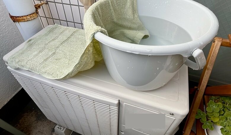 「室外機に濡れタオル」のイメージ（著者撮影）