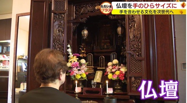 仏壇に手を合わせる人