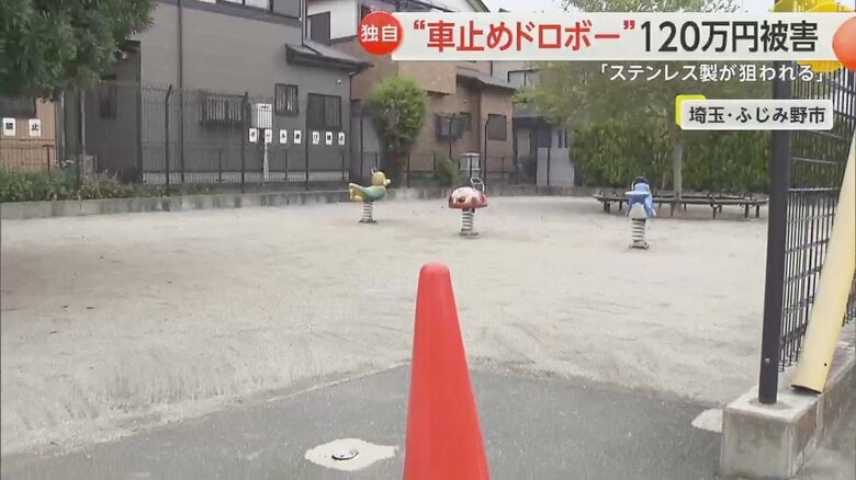 住宅に囲まれ、子ども用の遊具が設置されている車止めが盗まれた公園