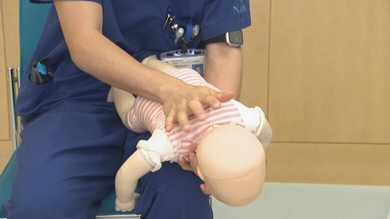 肩甲骨の間を手のひらで強くたたく