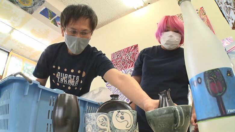 生徒が制作した作品を納品する岡部清人さん（左）