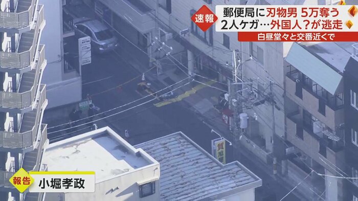 郵便局の玄関で鑑識による捜査が行われている
