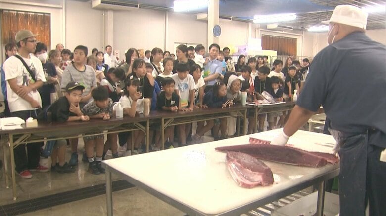 マグロの解体も目の前で…卸売市場で親子等向けの見学会 約70人が野菜や果物が競り落とされる様子見守る｜FNNプライムオンライン