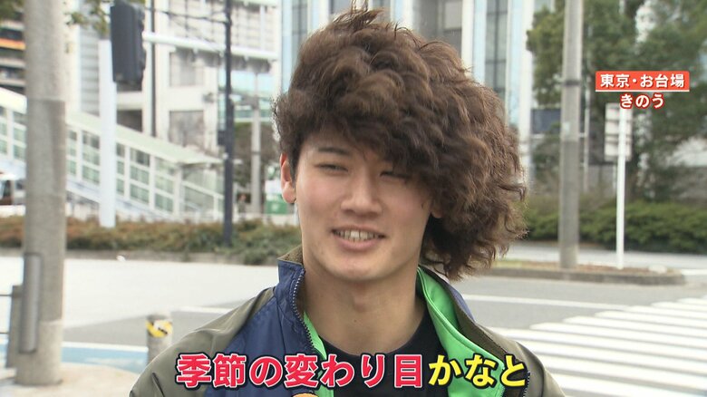 強風で髪が一方向に流れる男性