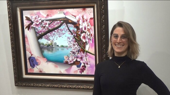 日本大使館に勤めるサラ・モリスさん(隣の絵画は2023年にワシントンDCで開催される「全米桜祭り」公式アート)