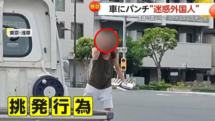 威嚇するように腕の筋肉を見せつけた外国人(FNN投稿サイト「ビデオPost」)