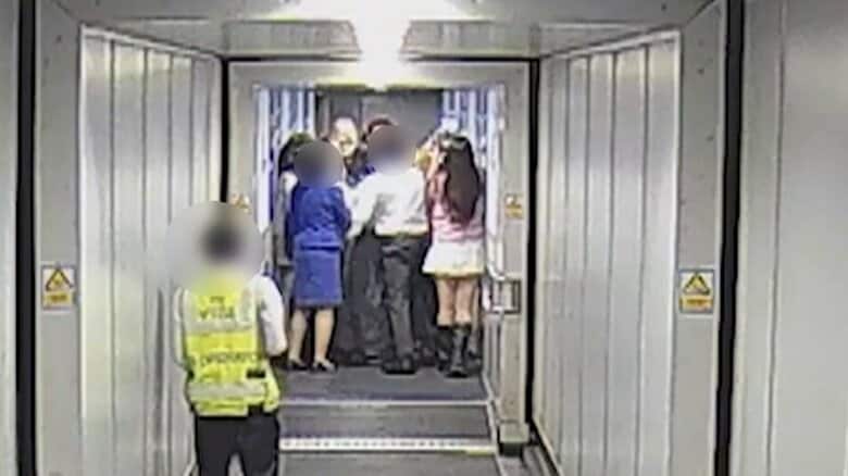 飛行機へと続く通路をもみくちゃになりながら進む中国人女性ファンら