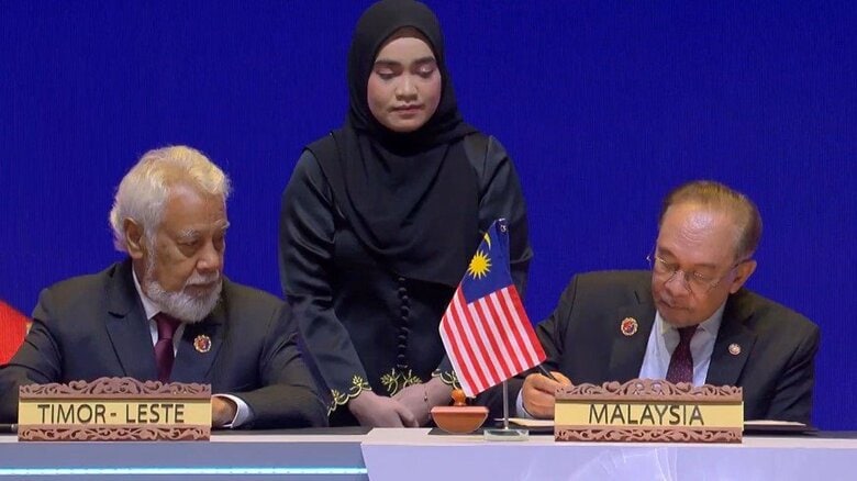 東ティモール加盟のサインをするアンワル首相と見守るグスマン首相