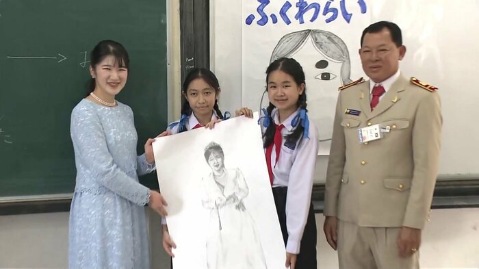 生徒たちが描いたデッサン画と手に記念撮影された