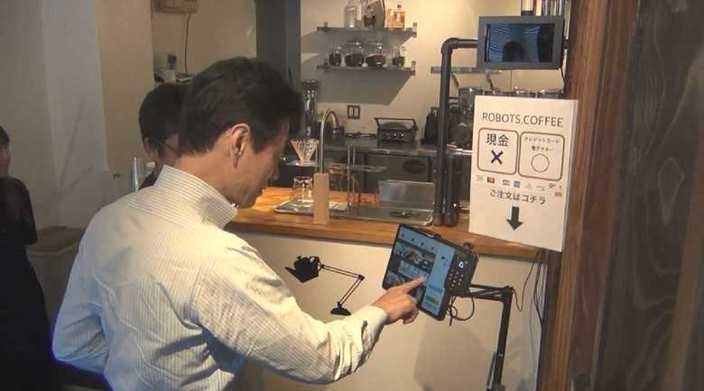 視察先のカフェでセルフ決済をする西村官房副長官 東京・中央区