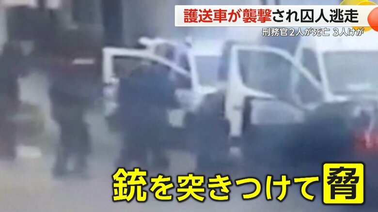 護送車から刑務官と思われる人を引きずり出し、銃を突きつけて脅している武装集団