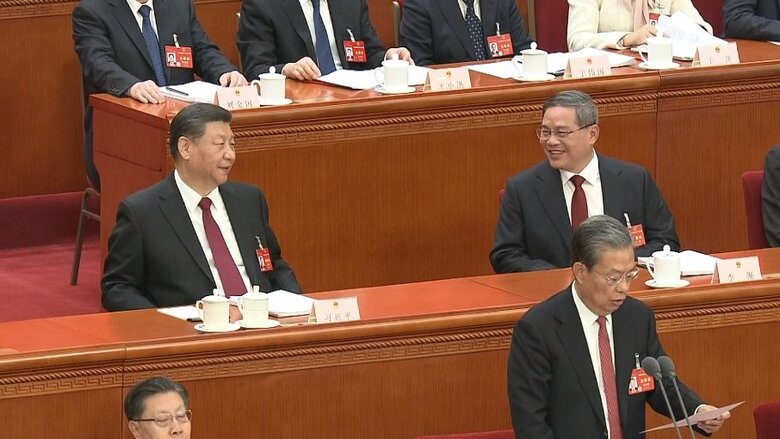 政府活動報告を終えたあと習主席に声を掛けられ笑顔になる李首相（3月5日）