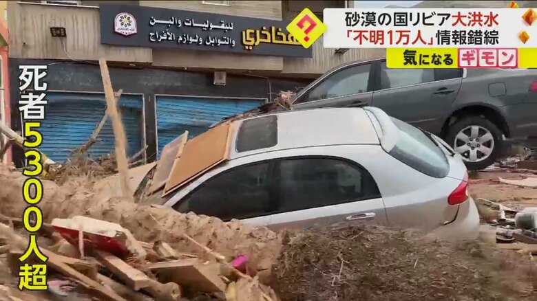 土やがれきに埋もれた車が止まっている