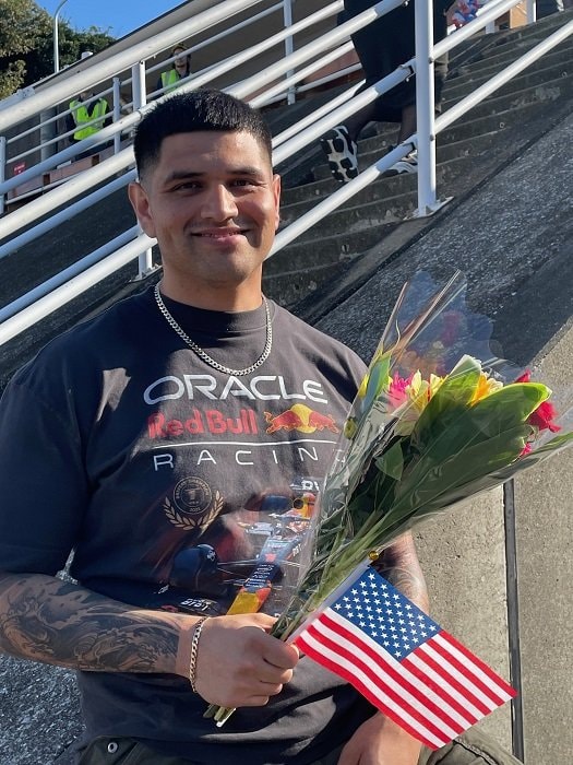 花束を手にガールフレンドを待つ男性。カメラを向けると優しく微笑んだ