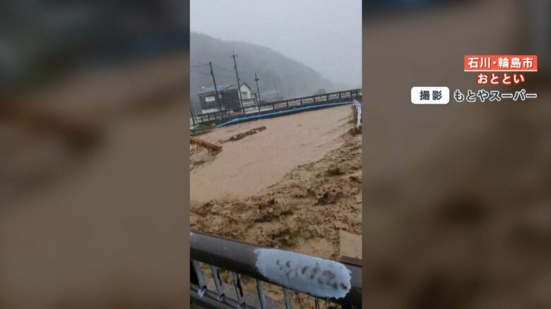 今にも橋をのみ込む勢いで流れる川