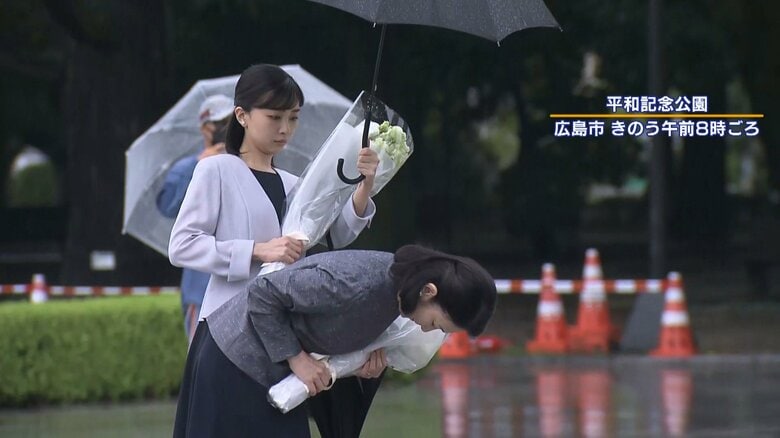 紀子さまがぬれないように傘を差し掛ける佳子さま