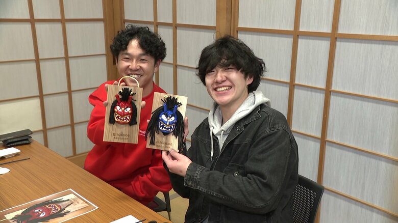 自分で色付けした壁掛けを手にする観光客