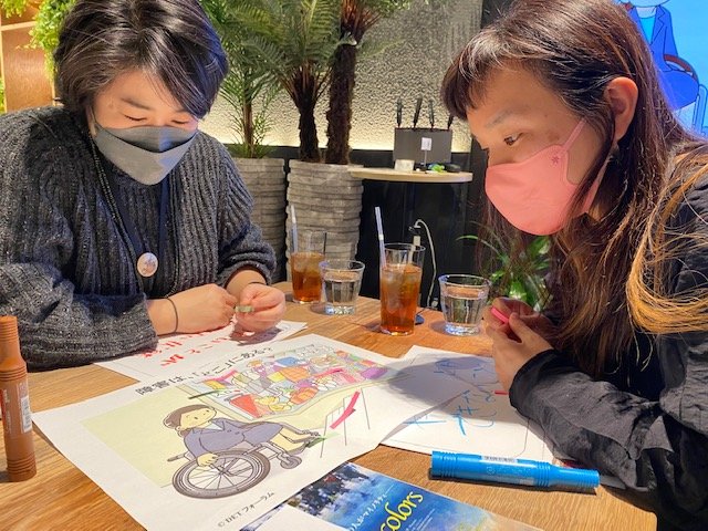 参加者は「障害はどこにあるのか?」議論しながらイラストに付箋を貼る