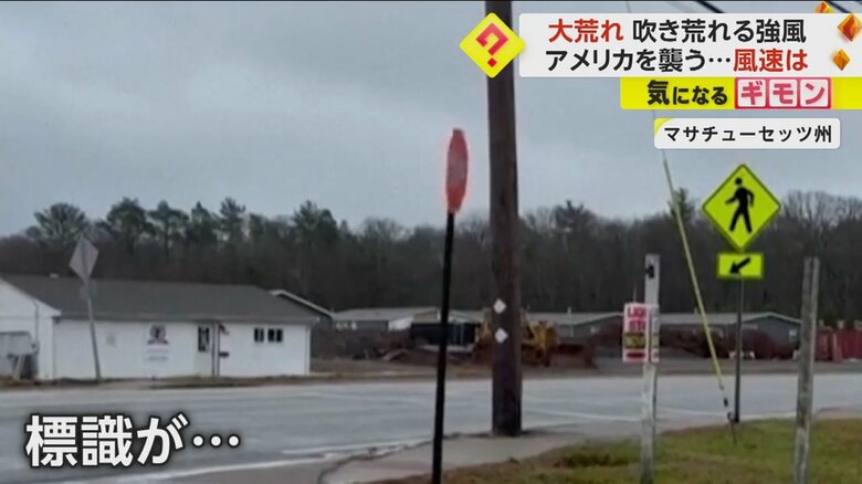 強い風で左右に揺れている道路標識